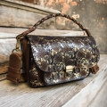 Lara leather handbag made of leather in gold color and brown accents.